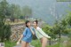 A couple of women standing next to each other on a road.