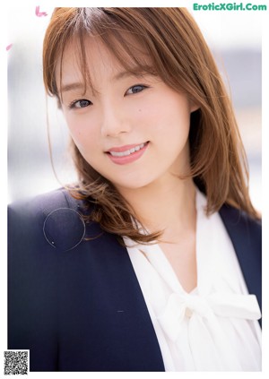 A woman in a white shirt and a black jacket.