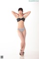 A woman in a black and white bikini posing for a picture.